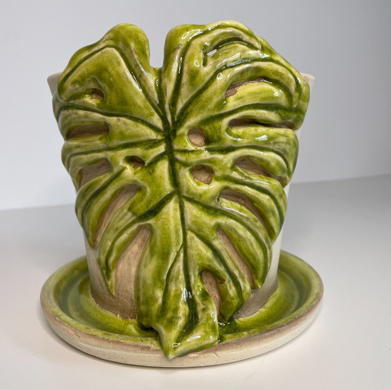 Hand thrown ceramic plant pot with a green monstera leaf motif for house plant enthusiasts