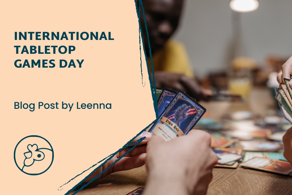 Players holding game cards as they sit around a table playing a board game. Source: Canva